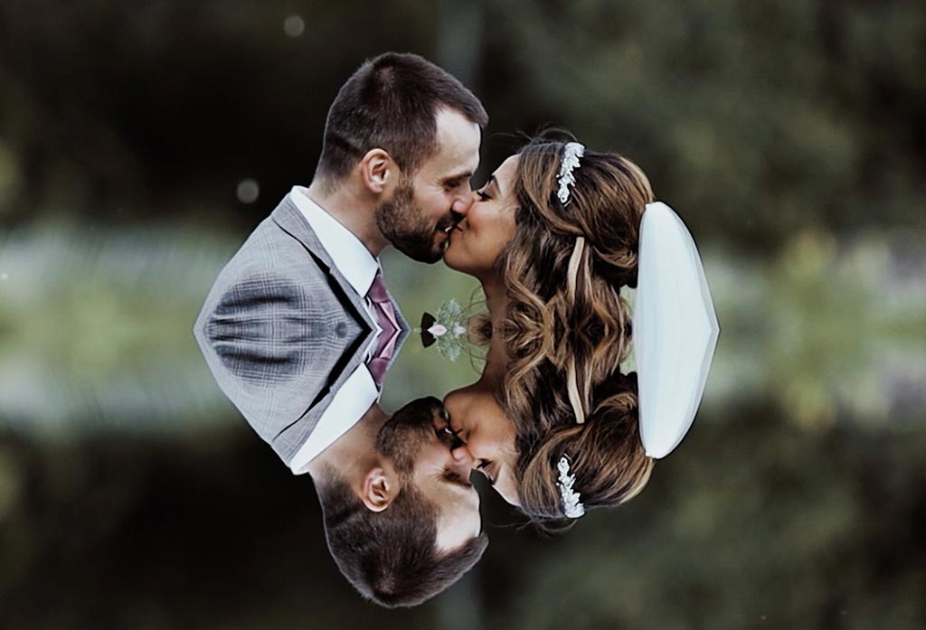 A kissing couple filmed by a wedding videographer