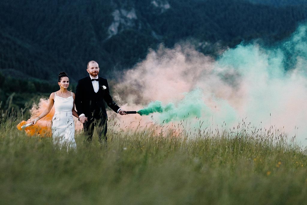 Para młoda ze świecami dymnymi kręcac film slubny w Tatrach w okolicy miasta Zakopane.